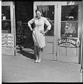 Image of Woman posing in front of grocery store, Seattle, circa 1950