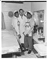 Image of Joe Louis with two young boxers backstage at an exhibition match, Seattle, circa 1950