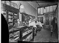 Image of Barbers with customers inside barbershop. Seattle, 1912