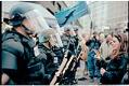 Image of Erin O'Connell facing line of police officers at WTO protest, Seattle, November 29, 1999