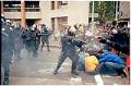 Image of Police officer pointing gas launcher at protesters at WTO protest, Seattle, November 30, 1999