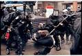 Image of Police pulling protester off armored vehicle at WTO protest, Seattle, November 30, 1999