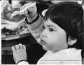 Image of Vietnamese child eating at Camp Murray, Washington, May 21, 1975
