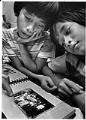 Image of Dai Vu and his brother looking at family photo, Seattle, October 14, 1979
