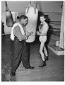 Image of Trainer and boxer in gym with heavy bag, Seattle, circa 1952