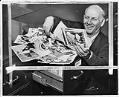 Image of Jeff Davis looking at newspaper photos of himself, Seattle, May 1952