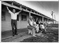 Image of Joe Garza and others outside worker housing at Golding Farms, Yakima Valley, May 1989
