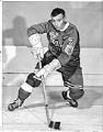 Image of Guyle Fielder posing on ice in hockey uniform, Seattle, 1958