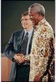 Image of Nelson Mandela and Bill Gates shaking hands at global health forum, Seattle, December 9, 1999