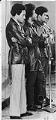 Image of Aaron Dixon, with bodyguards, speaking at rally at HUB Ballroom, Seattle, April 4, 1969