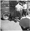Image of Officers escorting man to police van, Seattle, circa 1940