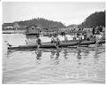 Image of Indigenous rowers carrying racing canoes into water, La Conner, November 29, 1941