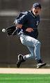 Image of Ichiro Suzuki trying to catch a baseball behind his back at training camp, Peoria, AZ, February 26, 2002