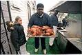 Image of Henry Williams carrying deep-fried turkeys outside Catfish Corner, Seattle, November 20, 2001