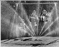 Image of Children swinging near sprinkler at View Ridge Playfield, Seattle, 1964