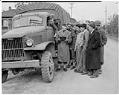 Image of U. S. Soldiers and Japanese Americans standing by truck, March 25, 1942