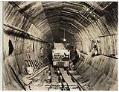 Image of Workers and car loaded with concrete in tunnel, circa 1929