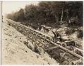 Image of Men in concrete transport car on tracks over sewer construction, circa 1925