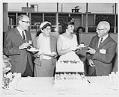Image of Seafair Princess Barbara Foy serving birthday cake at Washington Mutual's 75th anniversary celebration, September 21, 1964