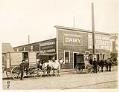Image of Two men with horse drawn delivery wagons outside of Kristoferson's Dairy, Seattle, circa 1914