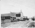 Image of Lone Pine Bar and Odd Fellows Hall on dirt road, probably Bainbridge Island, circa 1905