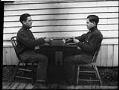 Image of Carl Henry Moen playing cards with himself in a double exposure, Seattle, circa 1910