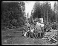 Image of Children and logging crew with a big log, circa 1903