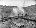Image of Workers using water hoses to regrade Denny Hill, Seattle, circa 1909