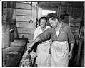 Image of Two men cooking in a kitchen of migrant camp, 1944