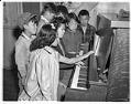Image of Teenage incarcerees gather at a piano, Puyallup Assembly Center, Puyallup, 1942