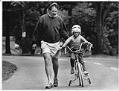 Image of Father teaching his daughter to ride a bicycle, Seattle, June 18, 1989