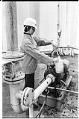 Image of Juanita Collins, chemical engineer, taking a sample for testing at the Monsanto plant, Seattle, December 16, 1973