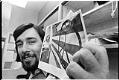Image of Harold Spence with a photo of his controversial peace symbol flag, June 28, 1974