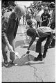 Image of Central Area residents painting a red line down the middle of Roy Street to protest red-lining bank policies, August 17, 1975