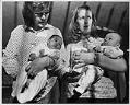 Image of Two women holding Vietnamese infants at Sea-Tac Airport, April 6, 1975