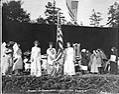 Image of Man in ancient Greek dress holding American flag at the 