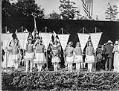Image of Young women in costume holding banners at the 