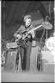 Image of George Harrison playing guitar at the Beatles concert, Seattle Center Coliseum, August 21, 1964