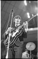 Image of George Harrison playing guitar at the Beatles concert, Seattle Center Coliseum, August 21, 1964
