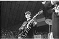 Image of George Harrison playing guitar at the Beatles concert at Seattle Center Coliseum, August 21, 1964