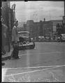 Image of Woman in work clothes waiting to cross street, Seattle, 1942