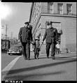 Image of Cheryl Chow in cowboy suit walking with policemen, April 1951
