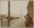 Image of Boy watching cavalry ride past Second and Pine, Seattle, August 7, 1900