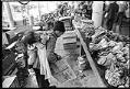 Image of Pike Place Market produce vendor carrying child on her back, Seattle, September 23, 1983