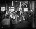 Image of Two white men and and Igorot man in car exhibit, Alaska-Yukon-Pacific Exposition, Seattle, 1909
