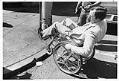 Image of Mike Kovell demonstrating that curbs can be a barrier for people in wheelchairs, Seattle, July 1978
